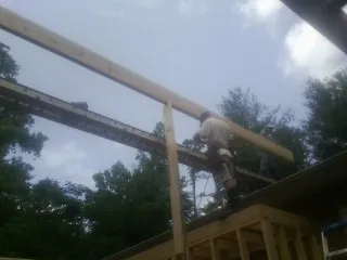 Carpenter setting a ridge beam over a new addition frame — Ice Dam Removal by Roofing Brothers in Deep Gap