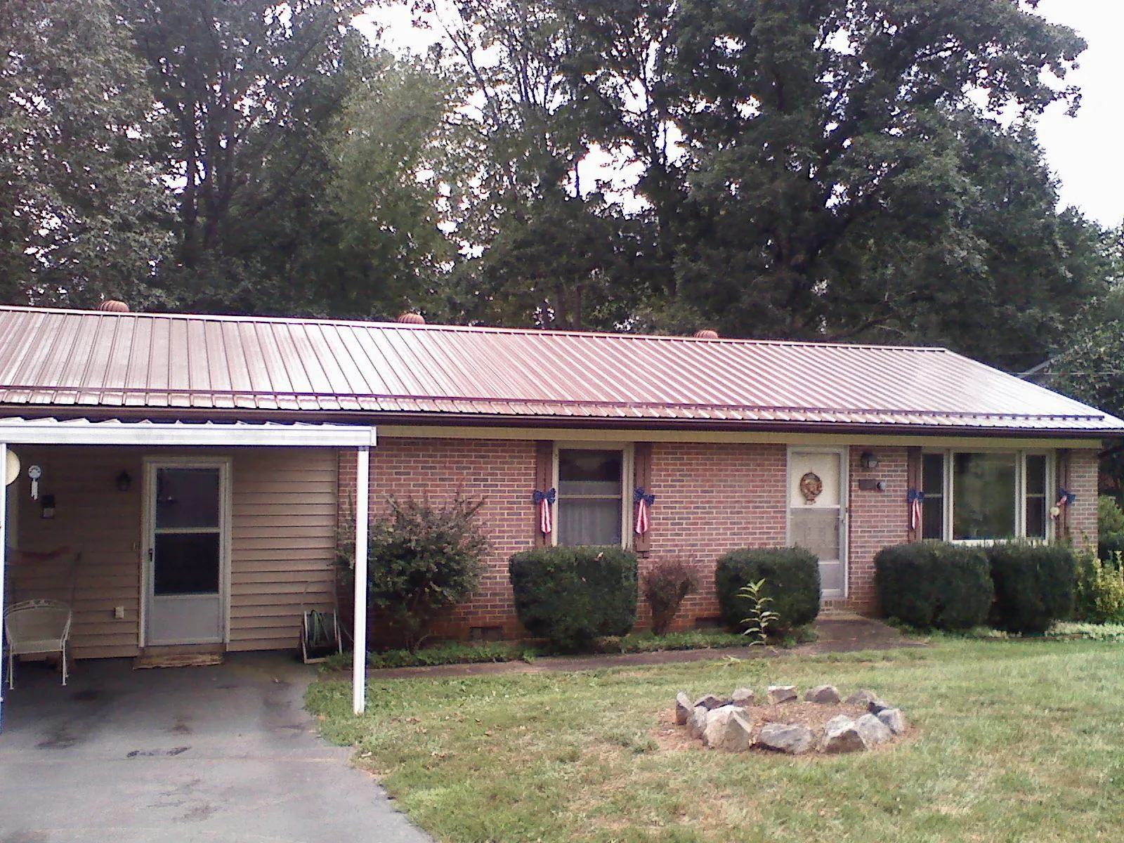 Bronze metal roof and carport on a brick ranch home — Roof Repair work by our crew in Deep Gap